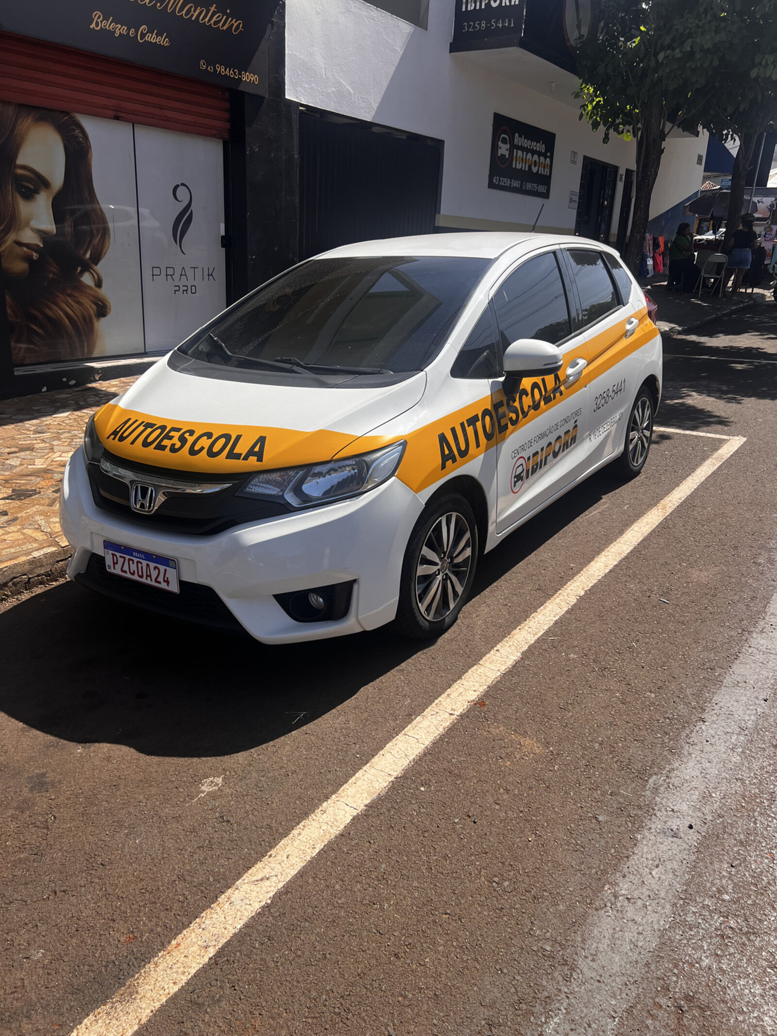 Honda Fit branco da Autoescola Ibiporã com faixa amarela